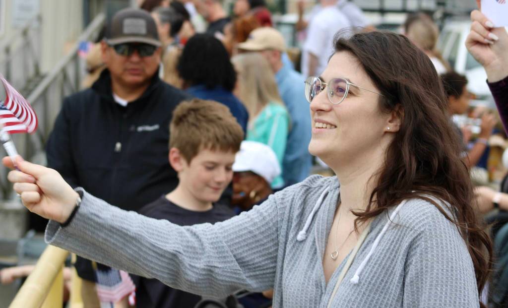Danielle Edwards waves her flag while watching the USS Ronald Reagan arrive in Bremerton.