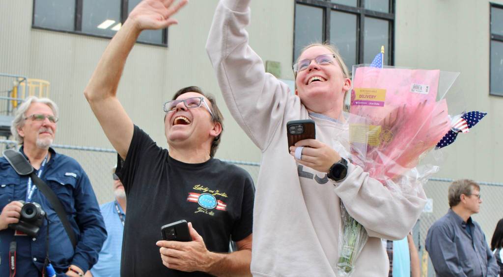 Don, left, and Carley Kunkle jump and wave at the sailor nearest and dearest to them.