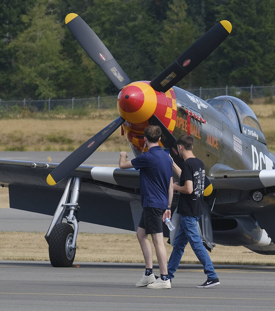 Two youths walk around the airport in Bremerton looking at some of the planes before takeoff.