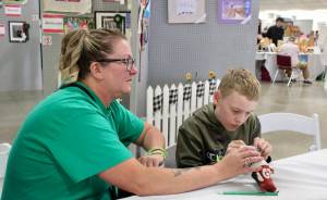 Elisha Meyer/Kitsap News Group photos
Seisha Hassett sits with her son Timothy, who is hard at work sewing fabric together at the Kitsap Fair and Stampede.