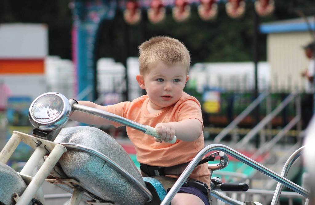 Walker Miller, 2, cruises along on one of the carnival rides