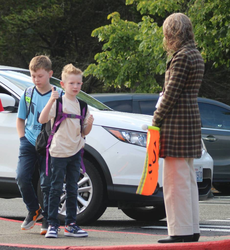 Students wait for the green light from reading teacher Michelle Robertson to cross the parking lot.