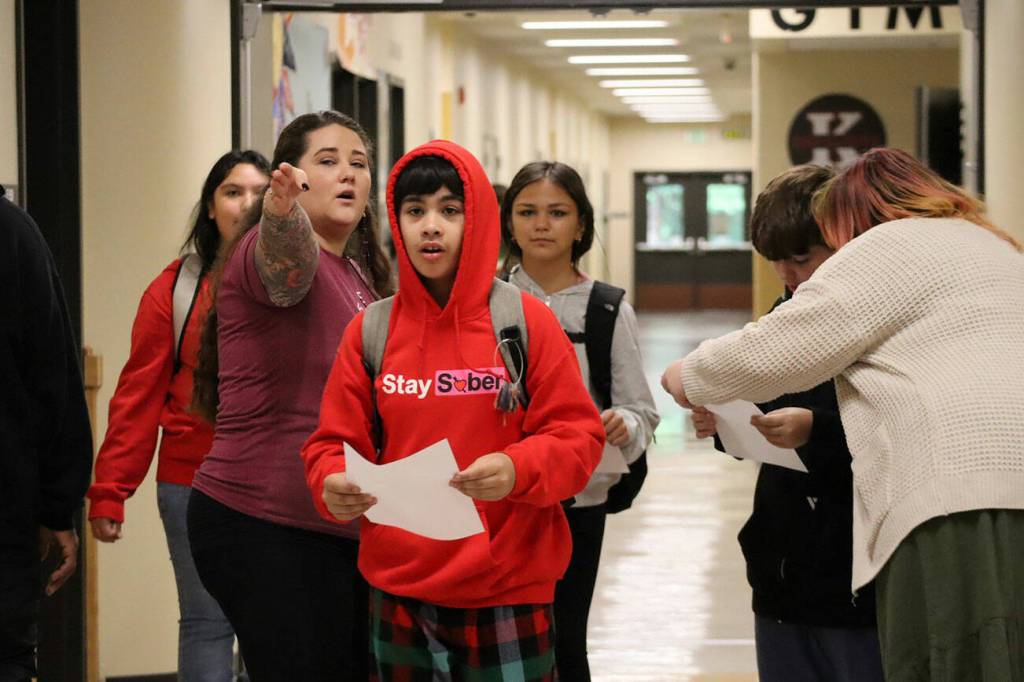 Kingston Middle School students receive their schedules while staff help point them in the right direction.
