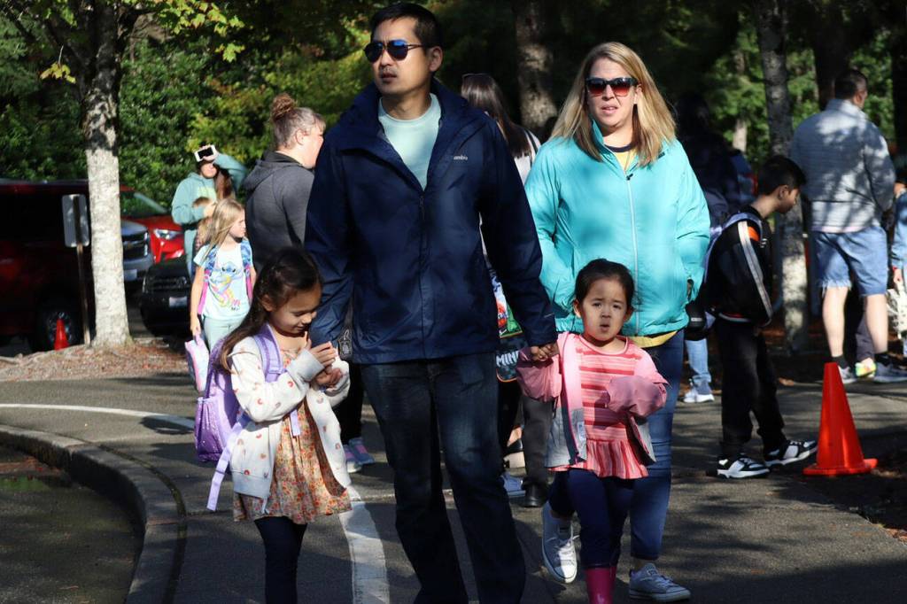 Parents walk their children to their first day of school Aug. 27.