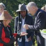 Bainbridge Mayor Joe Deets offers a gift to carver Randi Purser during the welcome pole dedication.