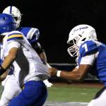 Elisha Meyer/Kitsap News Group photos
Olympic senior linebacker Gabriel Happili tugs on the jersey of Bremerton quarterback Anthony Medina.