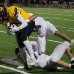 Bainbridge senior Isaiah Beyer is brought down by a pair of North Kitsap defenders.