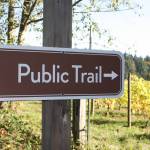 A new public trail sign marks the entrance to the new trail on Day Rd E.