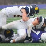 Three Spartans crunch an Anacortes receiver during a gang tackle at the game.