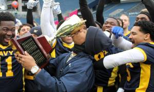 Elisha Meyer/Kitsap News Group photos
Navy coach Jason Henderson from Naval Station Everett certifies his teams 2-0 victory over Army at Lumen Field by planting a kiss of the trophy.