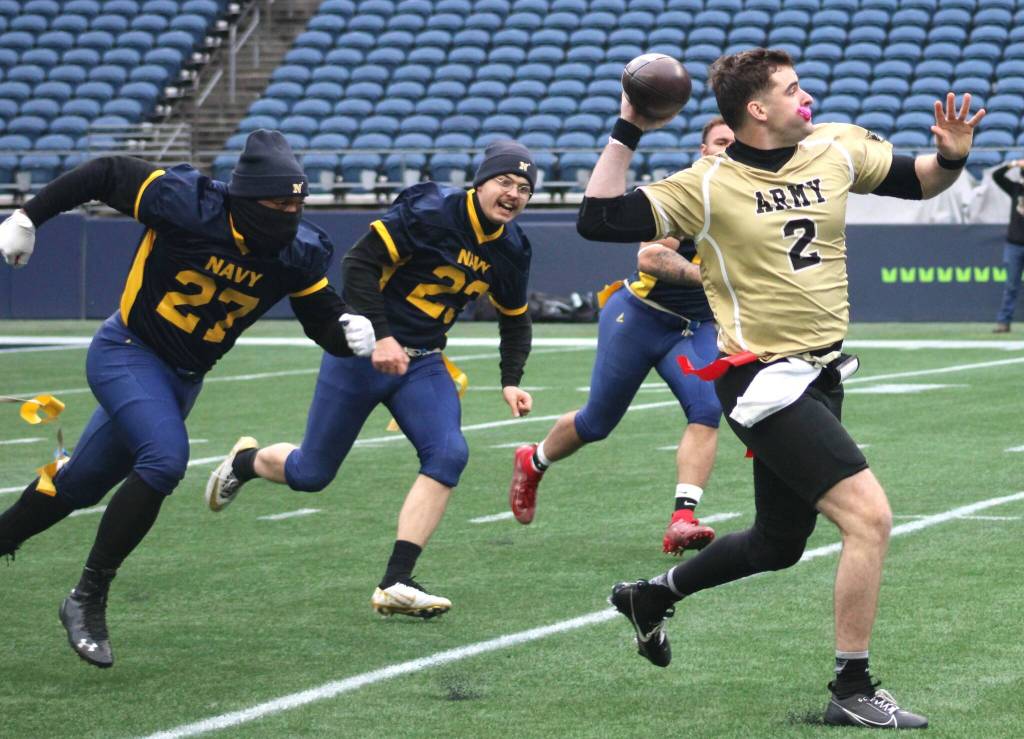 Navys defense tries to pull the flag of Armys scrambling quarterback.