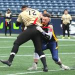 Navy linebacker Gage Pierson, right, wraps up a little too much around an Army receiver, drawing a penalty against Navy.