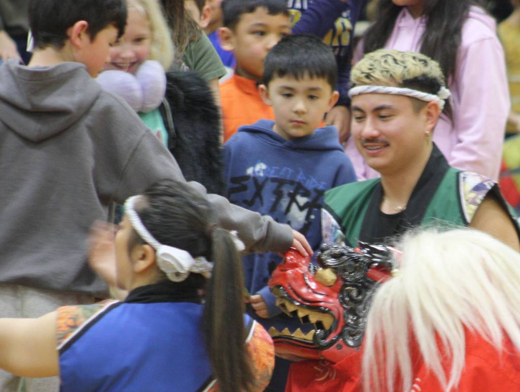 Seattle Kobon Taikos lion dancer visits with children after the show.
Seattle Kobon Taikos lion dancer visits with children after the show.
