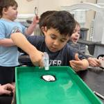The science experiment How do Penguins Stay Dry? included making a drawing of a penguin with crayons and then spraying water on it. The wax from the crayons repelled the water which mimicked how oil on penguins feathers keeps them dry.