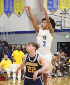 Luke Caputo/Kitsap News Group photos
With banners hanging in the background, Bremerton sophomore Aaron Matthews puts up a shot over Bainbridges Luke Johnson in a 75-42 win. The Knights talked about adding another banner to the collection with the win.