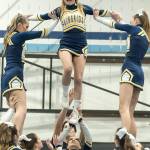 Luna Stein, left, and Grace Hungerford, right, support Grace Ross, center, as she balances on Teia McCoskery, below, during a pyramid stunt.