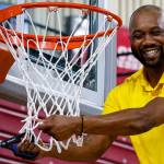 Bremerton coach Miah Davis cuts down the net following his teams state title win March 8.
