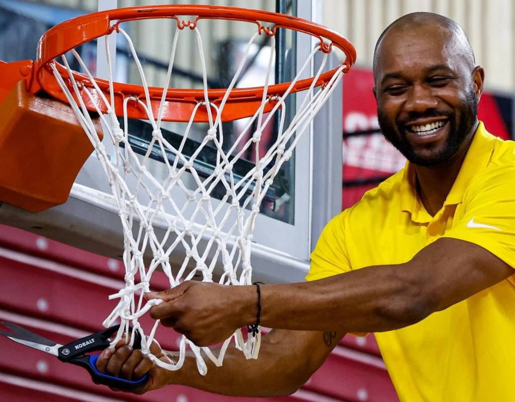 Bremerton coach Miah Davis cuts down the net following his teams state title win March 8.