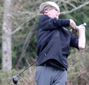 Luke Caputo/Kitsap News Group photos
Viking golfer Justin Gallant hits his ball through the rain in a 161-181 North Kitsap loss to the Bainbridge Spartans March 27 at the Wing Point Golf and Country Club on BI.