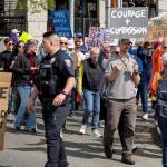 Marchers round the corner at Winslow Way and Madison Avenue, with police directing traffic.