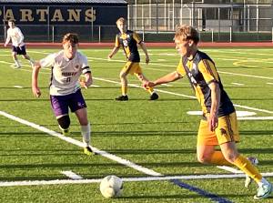 Luke Caputo/Kitsap News Group photos
Spartan Sampson Murchie dribbles the ball downfield with Viking defender Ethan Peck closing in during a 4-1 Bainbridge win over North Kitsap April 18 at Bainbridge High School.