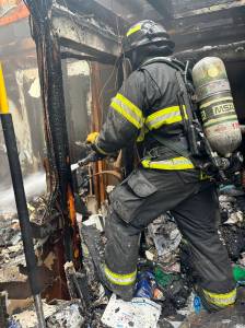 NKF&R courtesy photos
After stopping the fires progress within twenty minutes of arrival, firefighters spent another three hours digging through materials to find and extinguish remaining embers. Here, NKF&R firefighter Tucker Burns applies water to a hot spot in the homes bathroom.