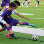 Viking Owen Leslie fights for the ball with a Quincy player during an opening round state match in Poulsbo May 21.