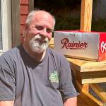 Mike De Felice/Kitsap News Group
Poulsbo carpenter Brian Nyjordet, alongside a case of Rainier Beer, which his famous motorcycle TV commercial helped promote.