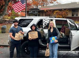 Chanel Fake courtesy photos
Josue May (left), Emilie May (center) and Lisa Johnson (right) pose outside of North Kitsap High School with their donations for the Port Gamble SKlallam Tribe.