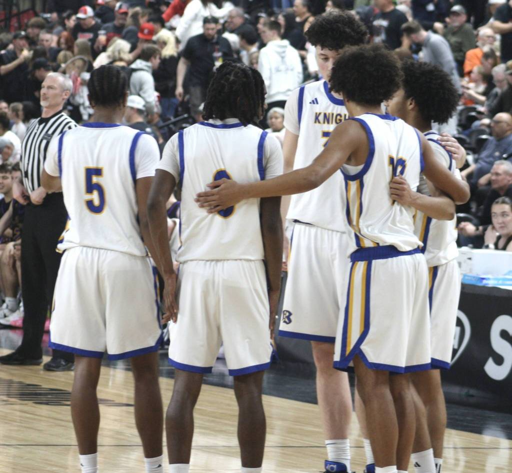 The Bremerton Knights huddle up during a 55-54 win over Columbia River March 6 in the semifinals of the 2A boys state basketball tournament at the Yakima SunDome.