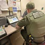 Deputy Corn seated in front of a breathalyzer machine. The arrestee refused to blow into the device.
